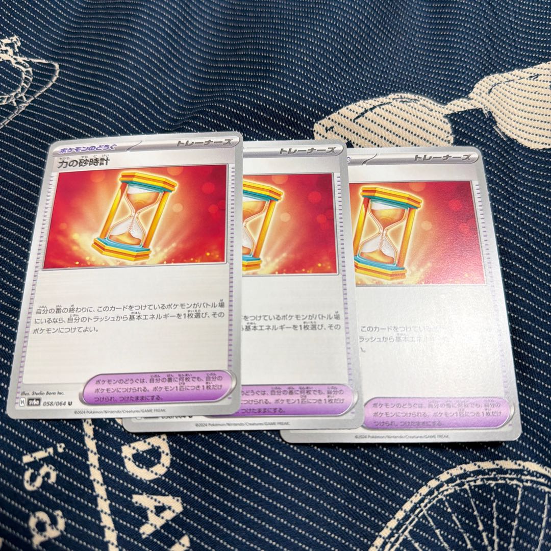 three flat objects (e.g. tickets, pieces of cloth, etc.) Hourglass of Power U 058/064