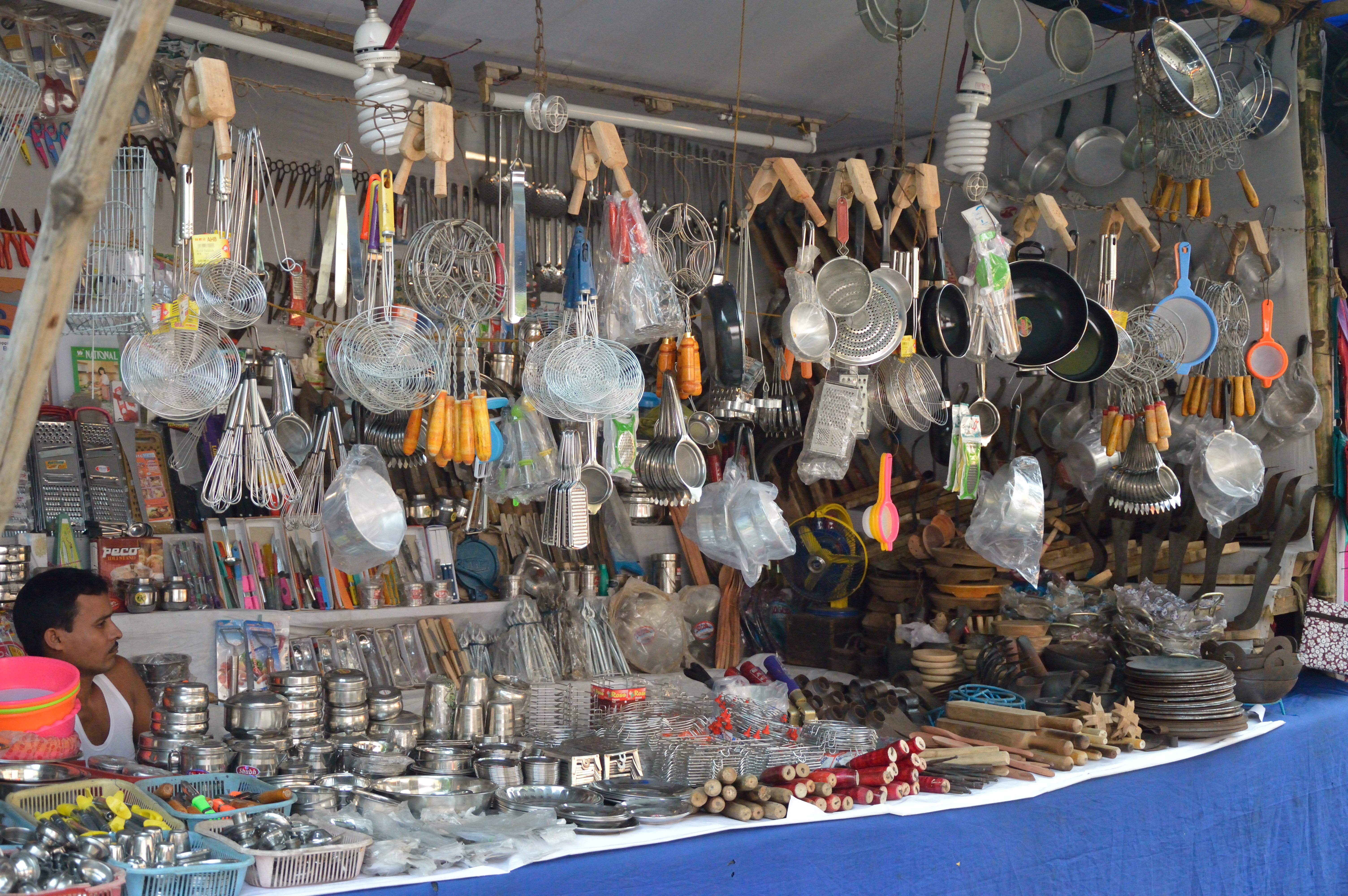 Stainless steel and brass utensils on display at an Indian market stall