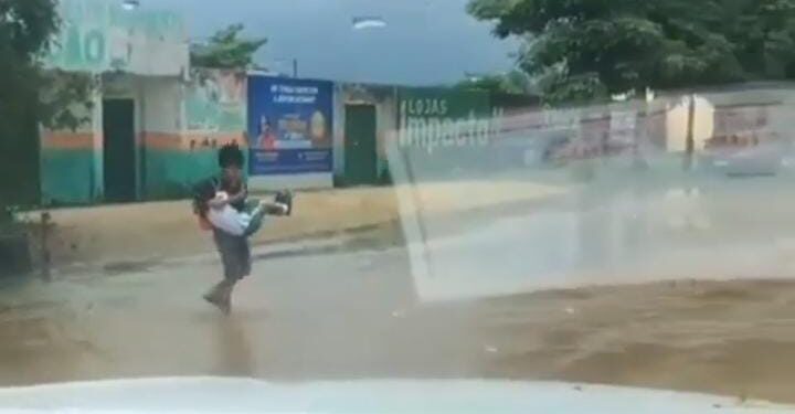 Vídeo de garoto ajudando irmãs a atravessa rua alagada viraliza nas redes sociais