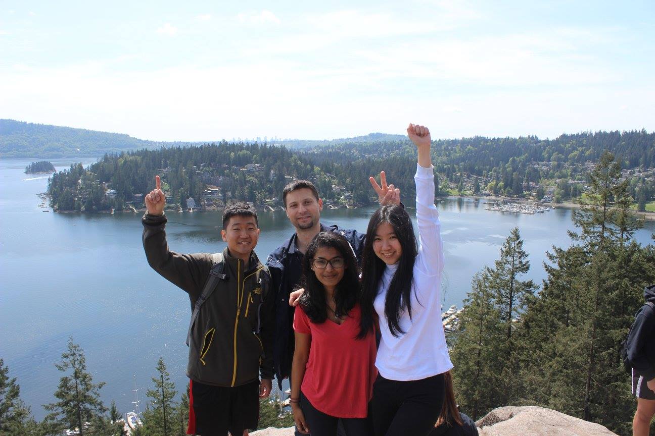 Andrew and friends posing on a mountain overlooking a lake