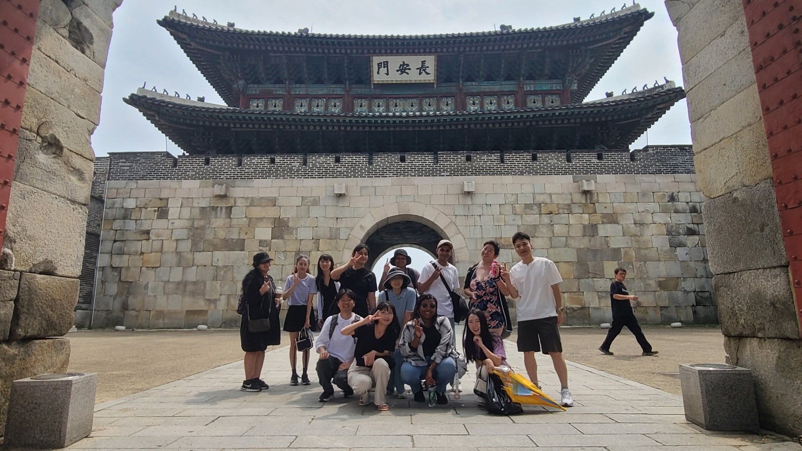 Diverse group posing in front of a traditional Korean gate