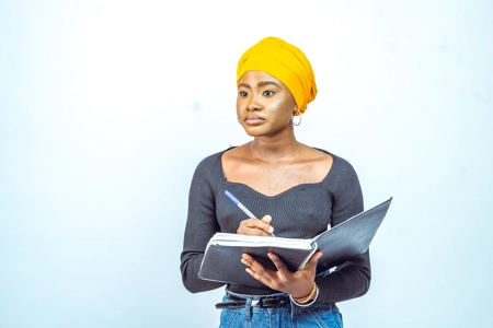 Belle jeune femme avec un foulard et son carnet de note