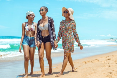 Des filles entrain de discuter mains dans ls mains à la plage