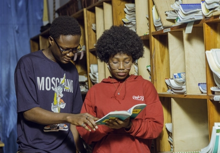 Des jeunes entrain de lire dans une bibliothèque