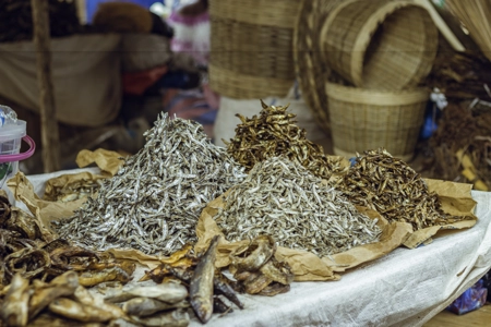 Des poissons séchés étalés sur une table au marché