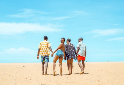 deux couples marchant main dans la main sur la plage