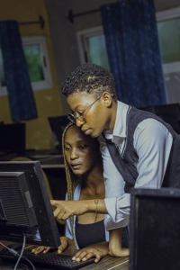 Deux étudiantes en salle d'informatique travaillant sur un poste