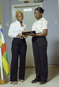 Deux étudiantes en uniforme dans le hall tenant une tablette