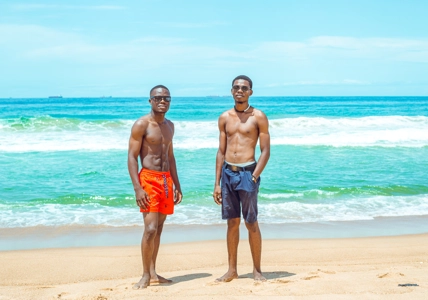 Garçons en culotte avec des abdos en bordure de plage