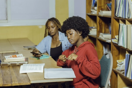 deux jeunes étudiante assises autour d'une table dans la bibliothèque