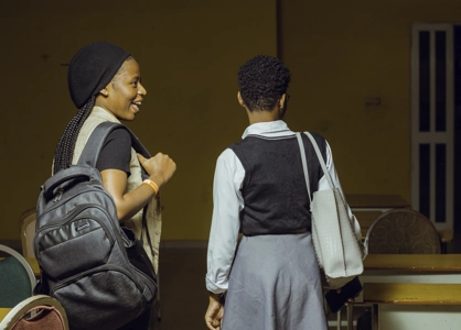 Deux jeunes étudiante sortant de la classe leur sac au bras en discutant