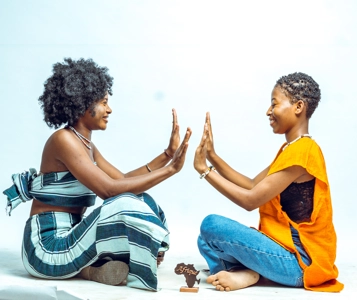 deux jeunes filles en tenues traditionnelles faisant des jeux africains