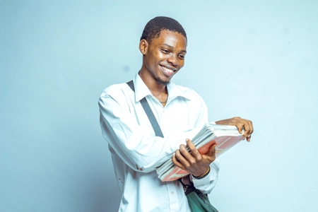 Etudiant heureux et souriant avec son sac et ses documents