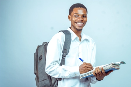 Etudiant souriant avec son sac au dos et ses documents