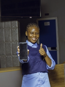 Etudiante souriante présentant un téléphone avec le pouce en l'air