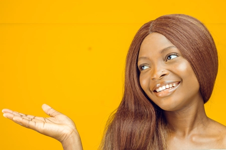 femme avec des cheveux soyeux et une peau lisse montrant un produit