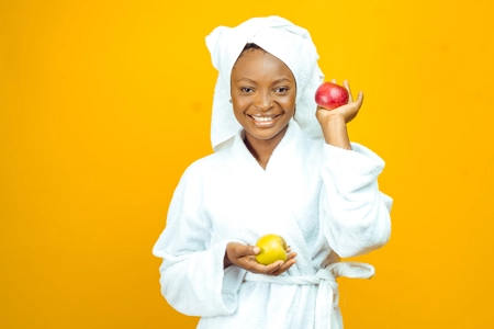 femme en peignoir blanc tenant des pommes