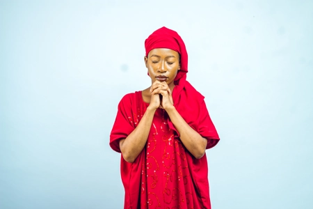 Femme en prière avec un voile rouge