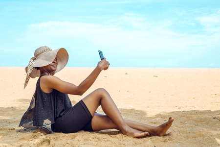 Femme faisant un selfi en bordure de plage