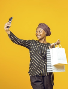 Femme faisant un selfie aves des sacs de shopping