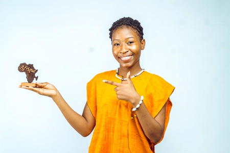 femme montrant une sculpture de l'Afrique avec sourire