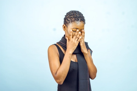 Femme pensive avec des problèmes et ces deux mains sur le visage