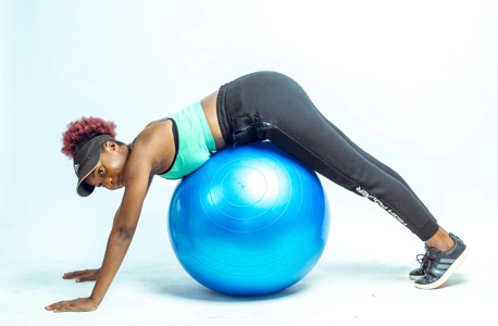 femme s'étirant avec un ballon de gym