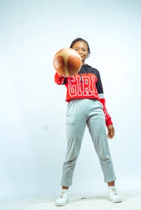 femme sportive en jogging montrant un ballon de basket