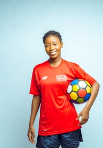 footballeuse en tenue de sport avec le ballon sous le bras