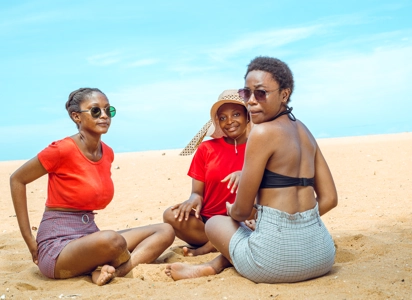 groupe de filles assises dans le sable profitant su soleil