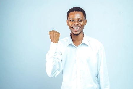 Homme heureuse avec un beau sourire et un poing levé