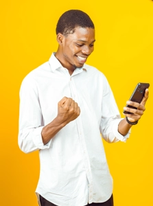 homme sautant de joie en regardant sur son téléphone