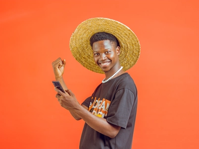 Homme souriant tenant un téléphone en main