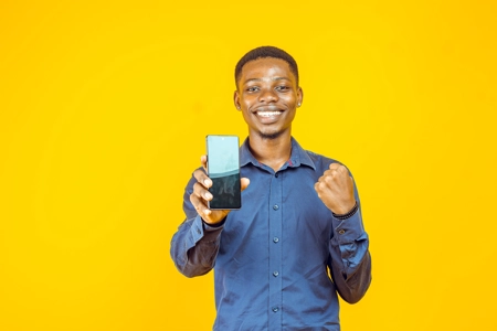 jeune homme sautant de joie montrant l'écran d'un téléphone