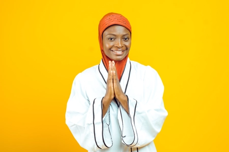 Un jeune femme musulmane souriant avec les mains jointes