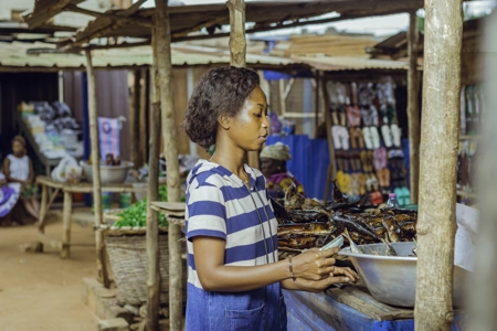 Une cliente devant la marchandise de poisson fumé