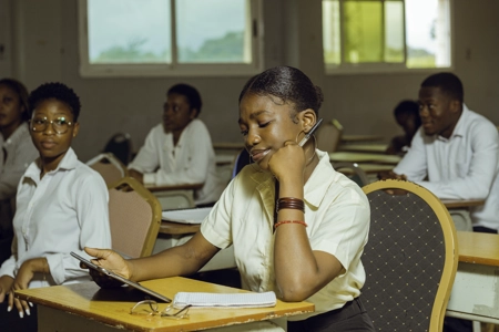 une élève réfléchissant à son devoir en salle de classe