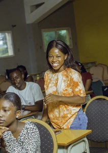 Une étudiante avec le sourire dans une salle de classe