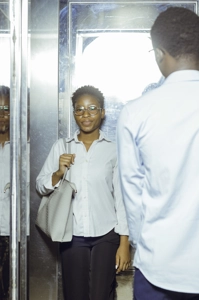 Une étudiante dans l'ascenseur attendant son camarade qui entre
