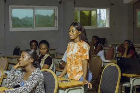 Une étudiante souriante debout en classe