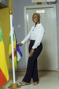 Une étudiante souriante en uniforme près d'un drapeau