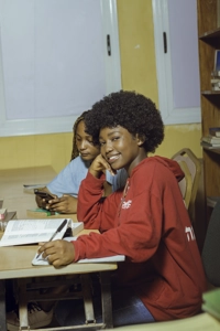 Une jeune fille dans une salle de classe entrain d'écrire