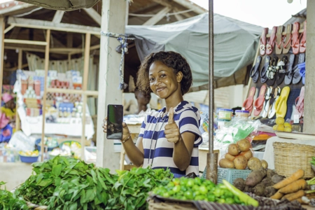 Une jeune fille heureuse avec le pousse levé au marché