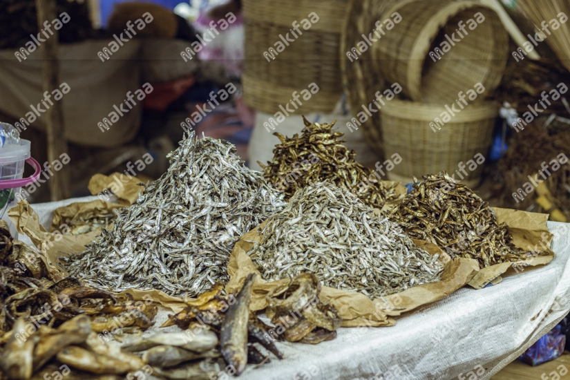 Des poissons séchés étalés sur une table au marché