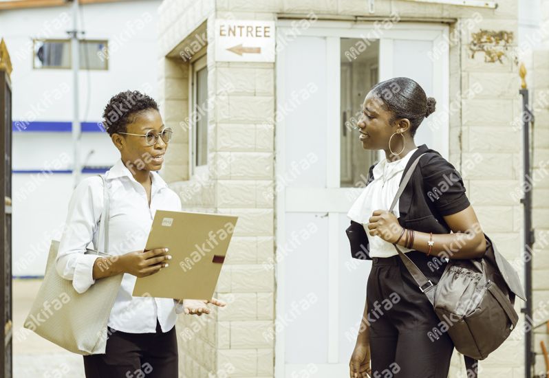 Deux étudiantes discutant à l'entrée de l'université