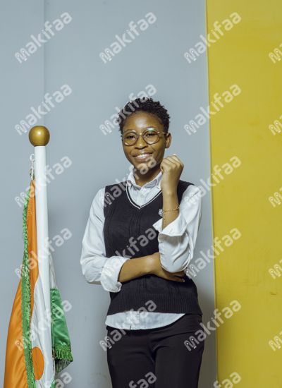 Une étudiante en uniforme près d'un drapeau