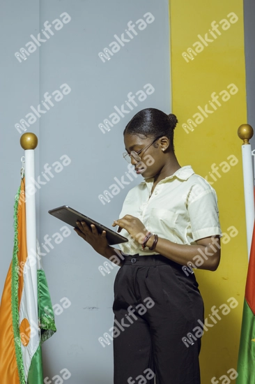 Une étudiante en uniforme regardant dans une tablette