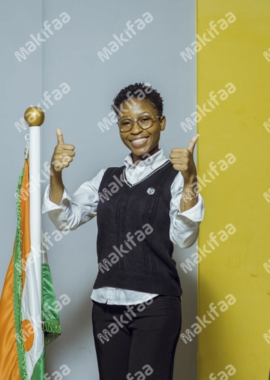 Une étudiante joyeuse en uniforme les pouces levés