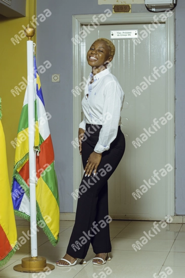 Une étudiante souriante en uniforme debout près des drapeaux