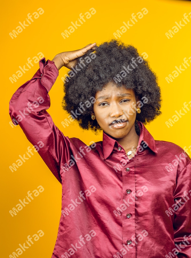 Belle femme étonnée  afro avec une main dans ces cheveux